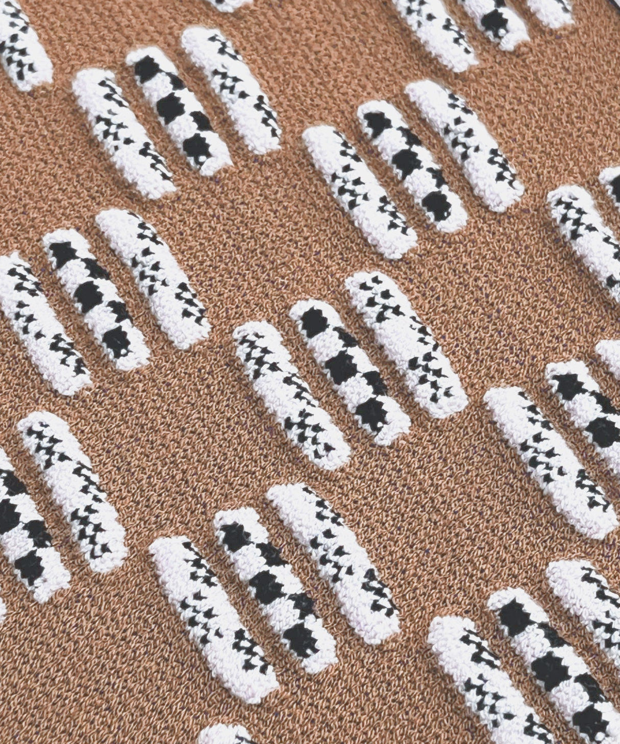 Patterned mat with black and white checkered design on a brown background
