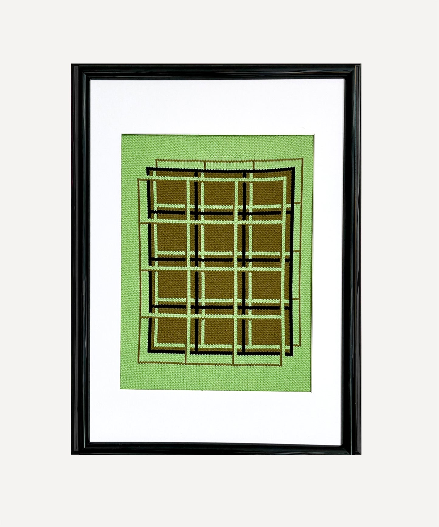 Framed artwork with geometric design on a green background