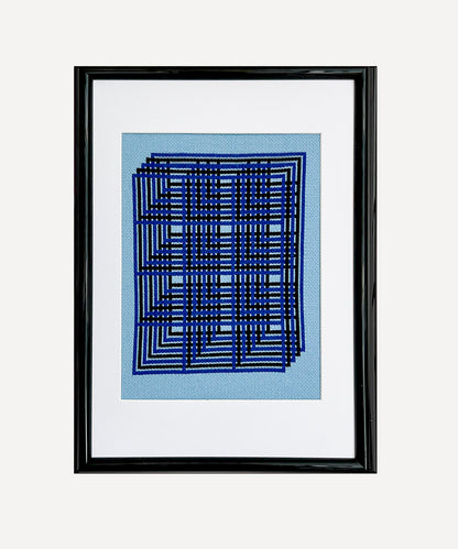 Framed abstract artwork with blue geometric design on a light blue background