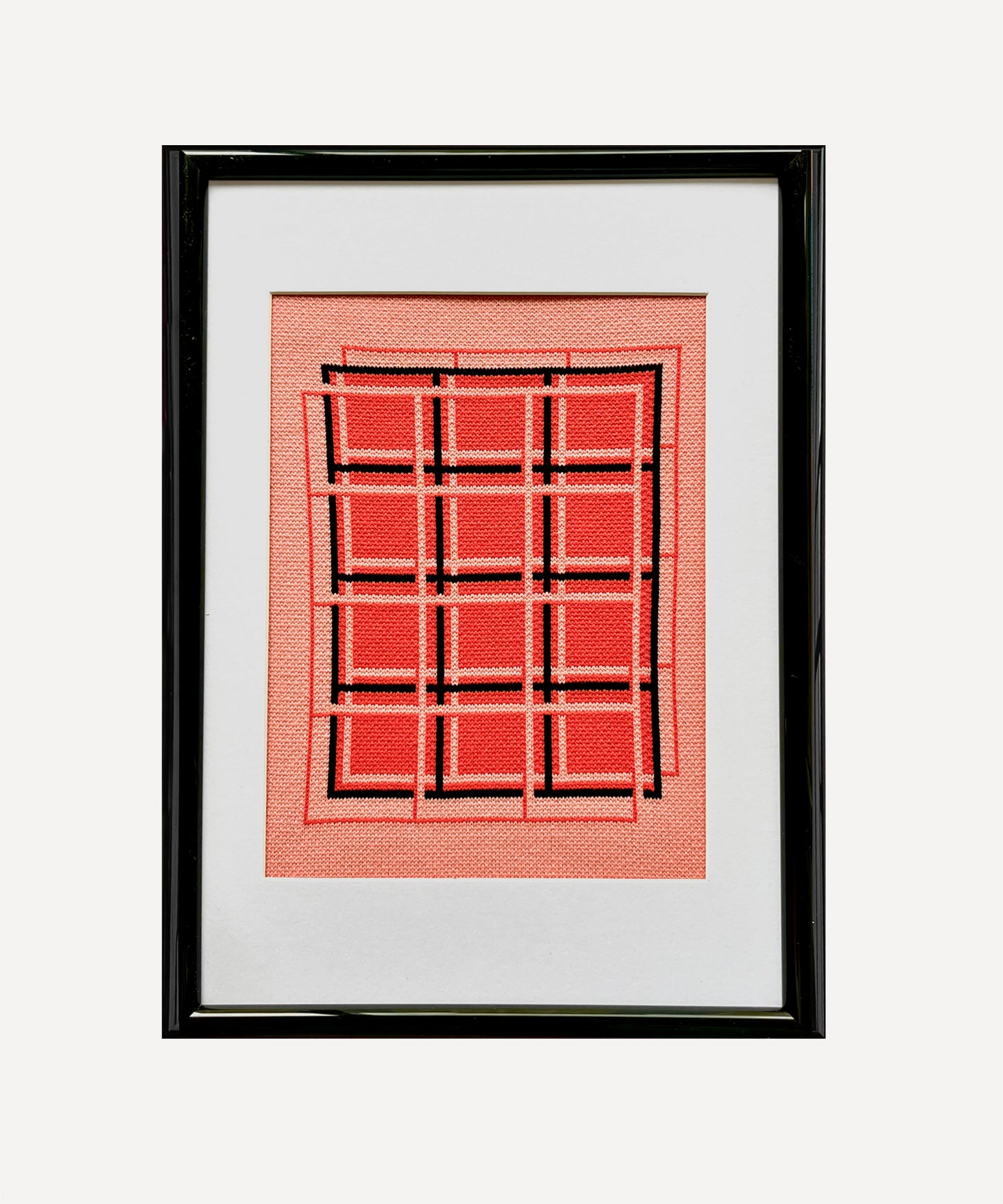 Framed artwork with a red geometric pattern on a white background