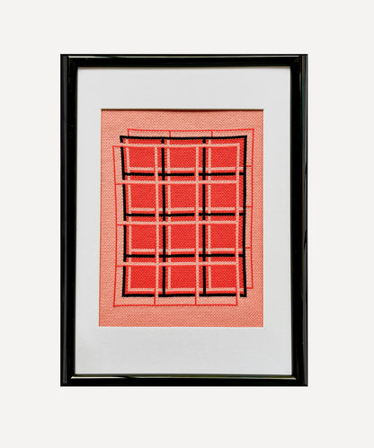 Framed artwork with a red geometric pattern on a white background