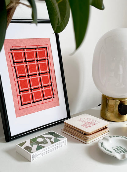 Framed abstract art piece on a table with decorative items