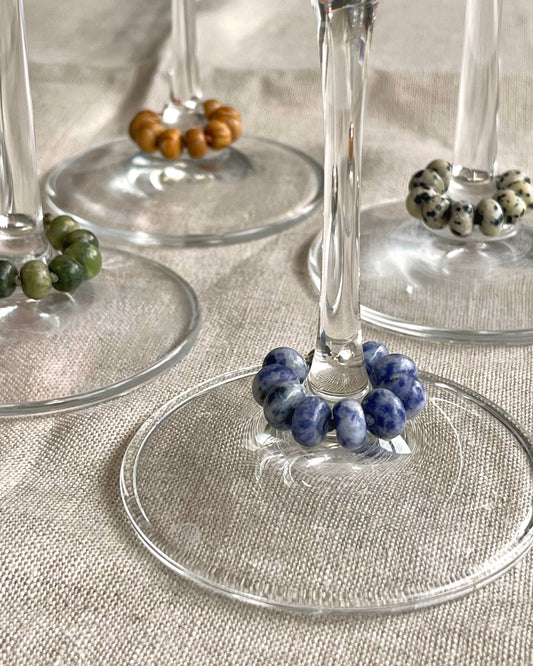 Wine glasses with decorative bead holders on a textured surface