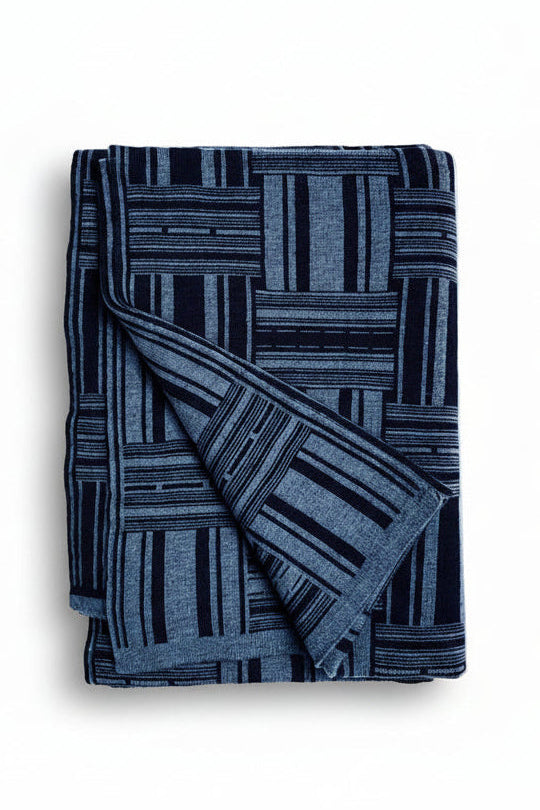 Folded blue patterned blanket on a white background