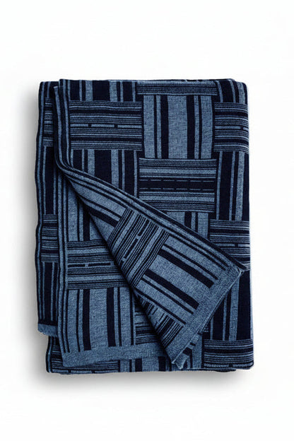 Folded blue patterned blanket on a white background